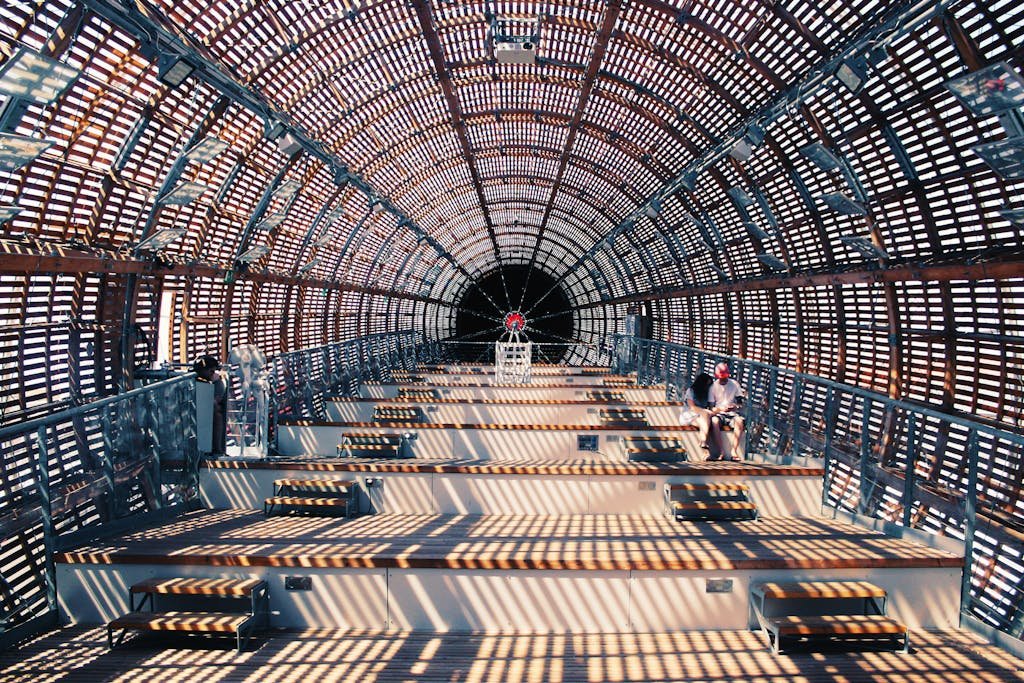 Futuristic interior architecture featuring geometric patterns and a single person seated inside.