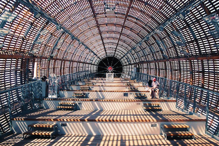 Futuristic interior architecture featuring geometric patterns and a single person seated inside.